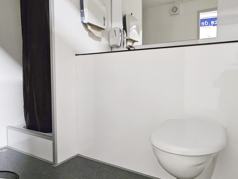 Innenraum mit Duschkabine und WC in einem mobilem Duschwagen zur Miete
