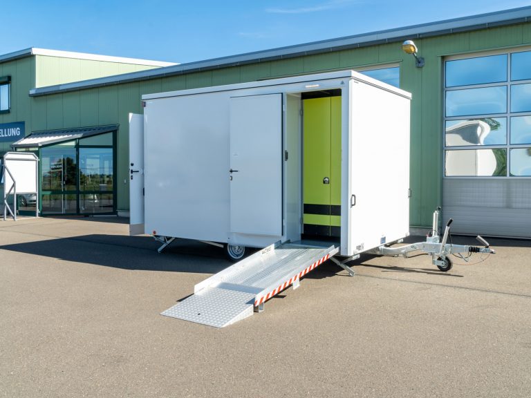 Barrierefreier Toilettenwagen vor einer Industriehalle