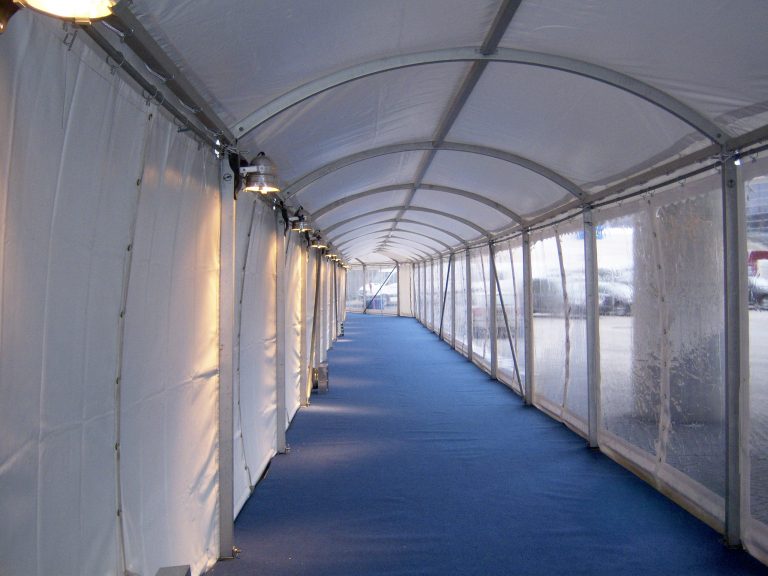 Innenraum eines Walkway-Zelts mit blauem Teppich.